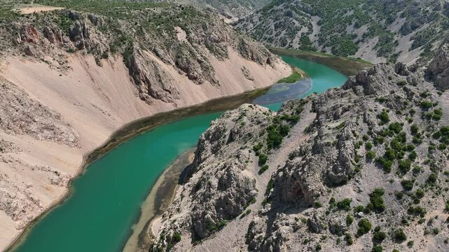 Aerial view where rivers Krnjeza and Krupa merge. Aerial shots of winding Zrmanja river cutting through deep canyon, lush spring colors and remote paths
