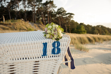 Brautstrauß auf Strandkorb bei Sonnenuntergang an der Ostsee