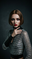 Stunning portrait of a model in a sleek, high‑contrast studio setting, wearing a shimmering metallic silver knit halter top paired with glossy, sculptural sleeves and high-waist bottoms.