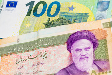 100 euro and 50000 Iranian rial banknotes. International trade concept