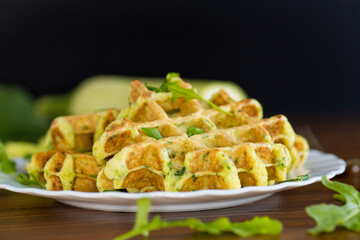 Crispy vegetable waffles served with herbs on a wooden table