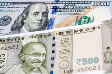 100 US dollar and 500 Indian rupee banknotes. International trade concept