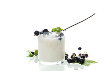 Healthy fermented milk product with berries and spoon on white background