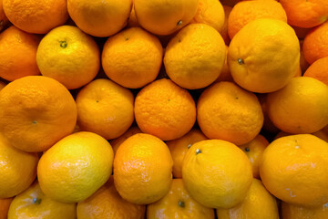 A vibrant pile of fresh mandarin oranges with textured peels displayed in a traditional market. Bright citrus fruits symbolizing freshness, health, and tropical abundance.