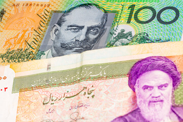 100 Australian dollar and 50000 Iranian rial banknotes. International trade concept