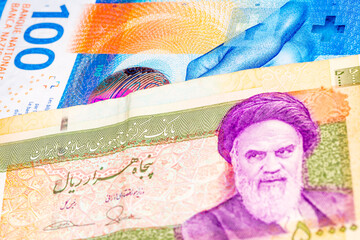 100 Swiss frank and 50000 Iranian rial banknotes. International trade concept