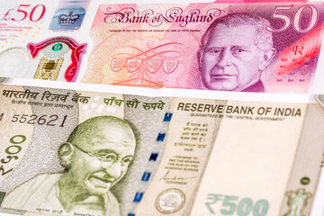50 British pound and 500 Indian rupee banknotes. International trade concept