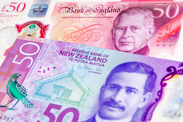 50 British pound and 50 New Zealand dollar banknotes. International trade concept