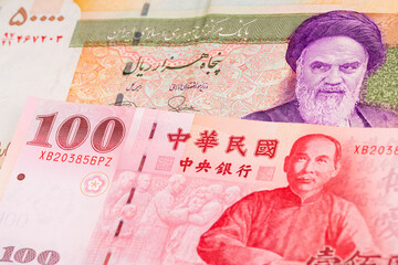 50000 Iranian rial and 100 Taiwanese dollar banknotes. International trade concept