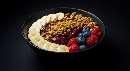 Indulge in this vibrant acai bowl, a symphony of fresh banana slices, juicy raspberries, blueberries, crunchy granola, and a sprinkle of bee pollen