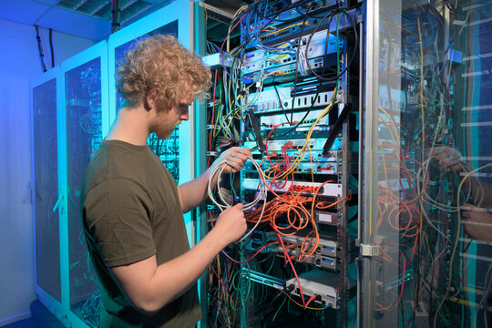 Technician working on network cables in a server room