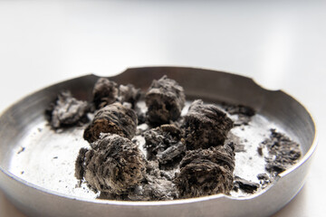 Cigar ash in metal ashtray