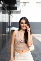Fototapeta premium Modern Asian Woman Using Phone Outdoors in City
