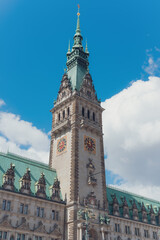 Obraz premium Elegant Tower of Hamburg Rathaus Set Against a Cloudy Blue Sky.