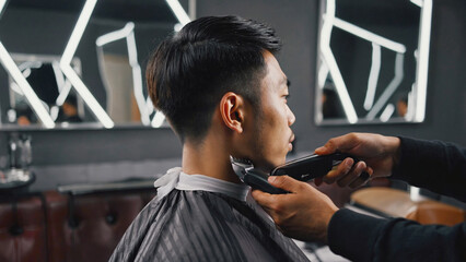 Man getting haircut at a barber shop with traditional tools and chair