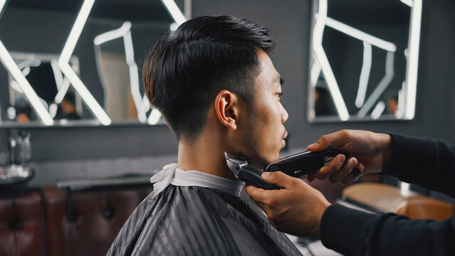 Man getting haircut at a barber shop with traditional tools and chair