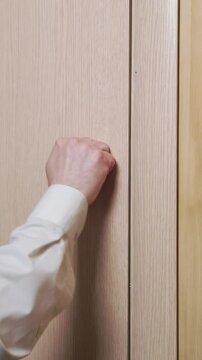Knocking on door. Man knock in house door. Close-up of someone's hand knocking on the door