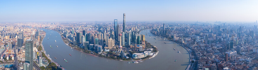 Fototapeta premium Aerial view of Shanghai skyscrapers in downtown with winding river on sunny day.