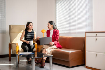 Businesswomen discussing using laptop in office