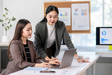 Fototapeta premium Businesswomen working together using laptop in modern office