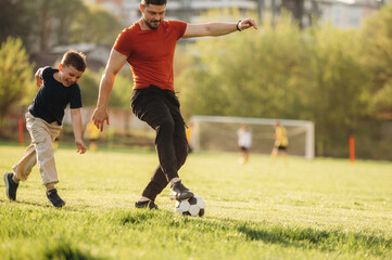 Game of soccer. Father and son are having fun outdoors