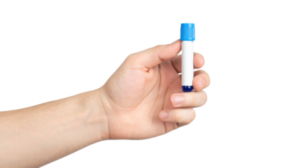 A hand holds a capped blue and white test tube against a black background.