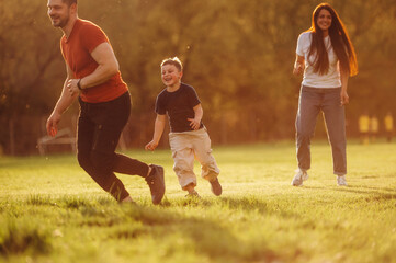 Family of mother, father and son are playing on the field