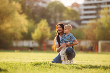 Looking far away. Mother and son are together on the summer field