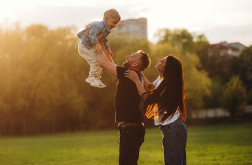 Family of mother, father and son are playing on the field
