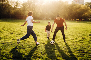 Soccer game. Family of mother, father and son are playing on the field