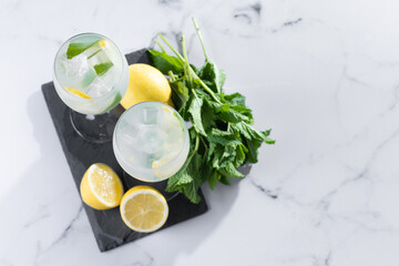 Hugo Spritz cocktail in glass on white marble background. Top view. Copy space