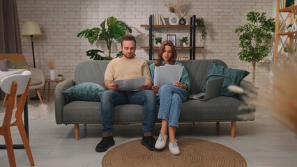 Obraz premium Couple Shopping Online Using Laptop on Comfortable Sofa