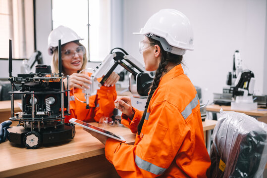 Female Robotic Engineer Checking Automation Robot Prototype in High-Tech Research Factory for Smart Manufacturing