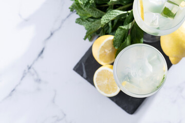 Hugo Spritz cocktail in glass on white marble background. Top view. Copy space