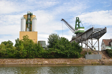 Riverside Industrial Site with Silos and Loading Crane 