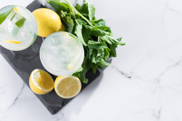 Hugo Spritz cocktail in glass on white marble background. Top view. Copy space