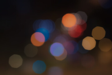 Group of multicolor soft octagon bokeh at night shown reflection from street lighting on wet road....