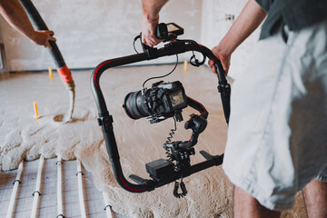 Videographers filming concrete surface flooring installation with professional camera