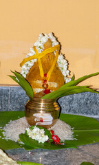 Sacred Kalash Setup with Coconut, Flowers, and Rice in Hindu Ritual