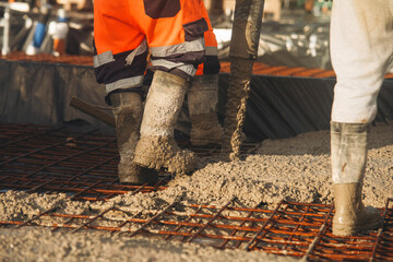 Close-up of Builders pouring floor slab from concrete pump