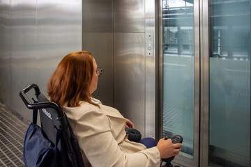 Woman in wheelchair waiting for elevator in subway station. Concept of inclusion, adapted public