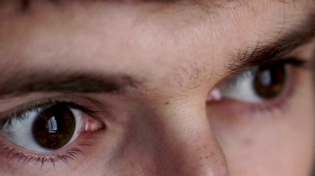 Human eye iris opening pupil extreme close up slow motion 60fps 4k Extreme close up shot of a man's blue eye opening and looking straight at camera