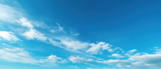 Fototapeta premium The serene blue sky with soft clouds creating a peaceful atmosphere.