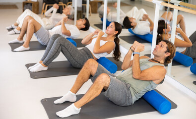 Fototapeta premium Group of different people performs sports exercises in fitness center