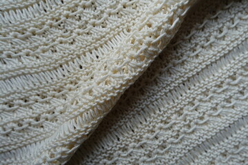 Diagonal soft fold on light beige handmade crochet lacy fabric