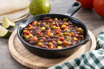 Mexican chilli beans with vegetables on wooden table