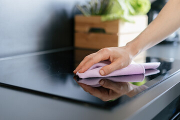 Modern kitchen cleaning with a woman using a cloth on the countertop