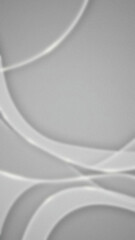 Abstract gray background showing light curves forming a circular pattern with soft blurred edges smooth textured surface