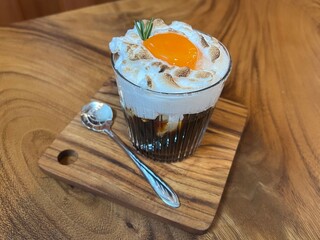 Black coffee with whipped egg white foam, finished with an egg yolk on top