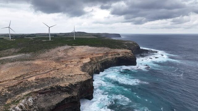 Drone Reveal of Wind Turbines on Rugged Cliffs by the Ocean at Cape Bridgewater